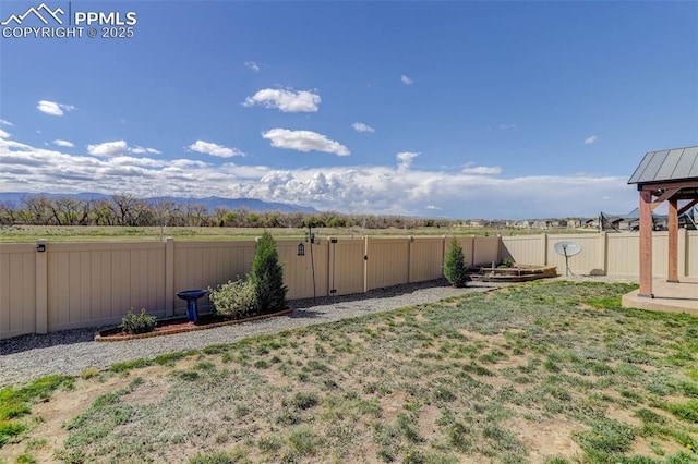 view of yard with a fenced backyard and a mountain view