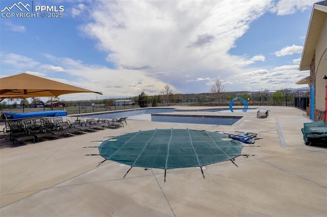 community pool featuring a patio and fence
