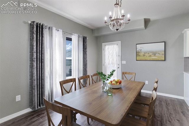 dining space featuring a notable chandelier, baseboards, and dark wood finished floors