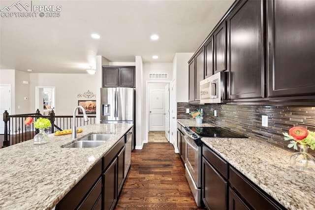 kitchen featuring dark hardwood / wood-style floors, tasteful backsplash, sink, light stone counters, and stainless steel appliances