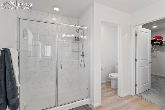 bathroom featuring hardwood / wood-style floors, toilet, and walk in shower