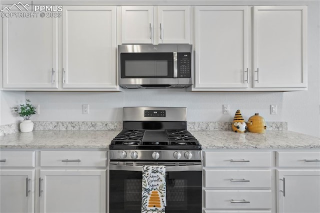 kitchen featuring light stone countertops, appliances with stainless steel finishes, and white cabinets