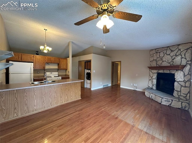 kitchen featuring washer / clothes dryer, sink, light wood-type flooring, white appliances, and a textured ceiling