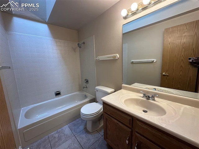 full bathroom with tiled shower / bath, vanity, tile patterned floors, and toilet