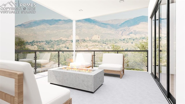 balcony featuring a mountain view and an outdoor fire pit