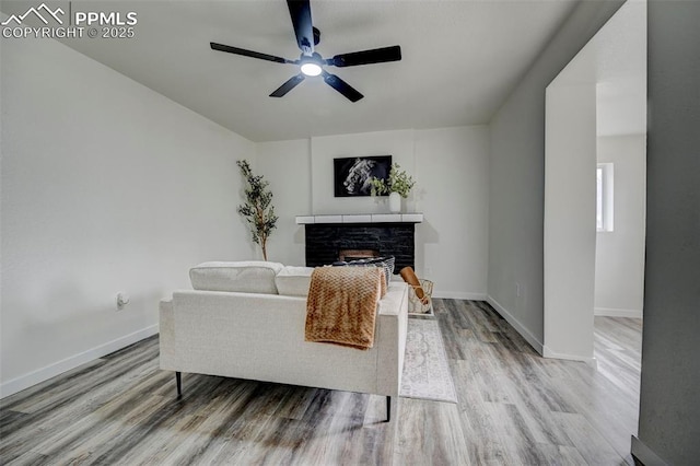 living room with light hardwood / wood-style floors and ceiling fan