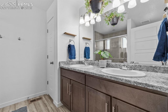 bathroom featuring vanity, wood-type flooring, and a shower with door