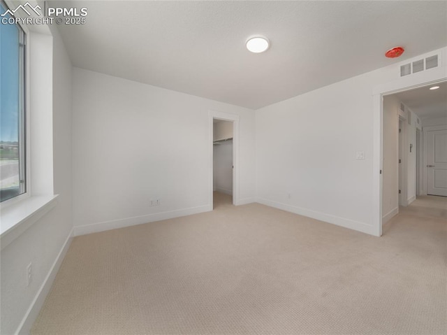 unfurnished bedroom with light carpet, baseboards, and visible vents