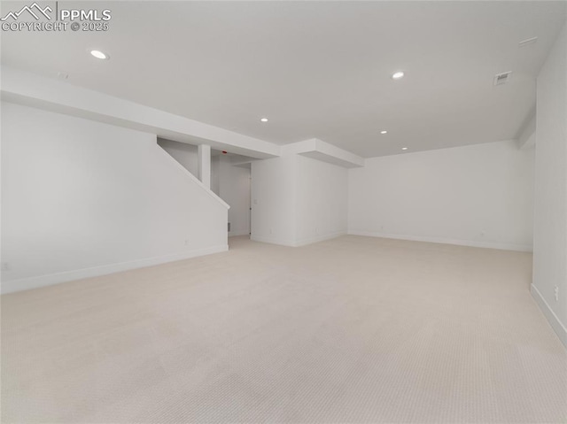 finished below grade area featuring light colored carpet, baseboards, stairway, and recessed lighting