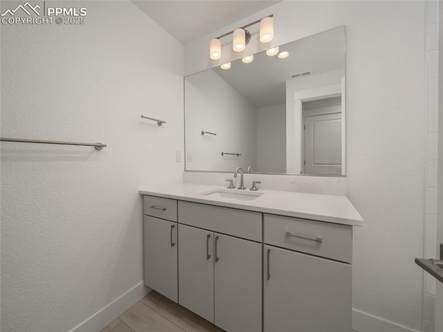 bathroom with vanity, baseboards, and visible vents