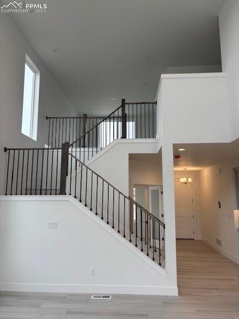 stairs with visible vents, baseboards, and wood finished floors