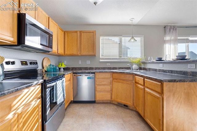 kitchen featuring sink, hanging light fixtures, and appliances with stainless steel finishes