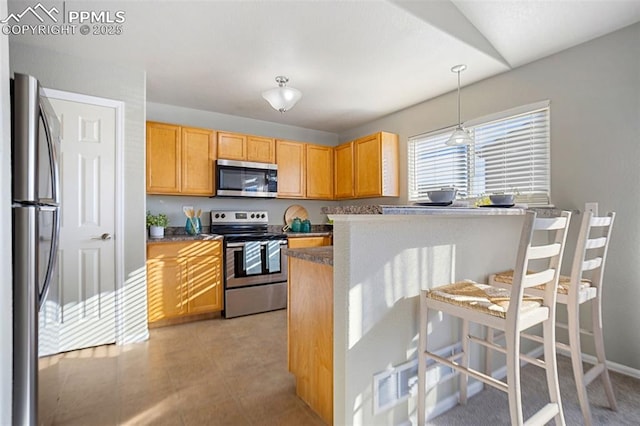 kitchen featuring stainless steel appliances, vaulted ceiling, a breakfast bar, and decorative light fixtures