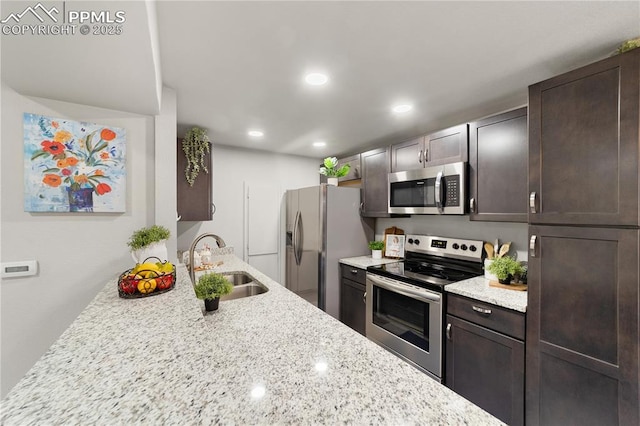 kitchen featuring sink, dark brown cabinets, light stone countertops, and appliances with stainless steel finishes