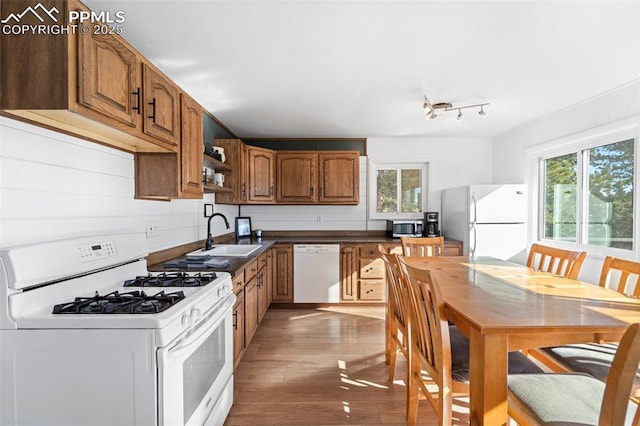 kitchen with white appliances, sink, light hardwood / wood-style flooring, and a wealth of natural light