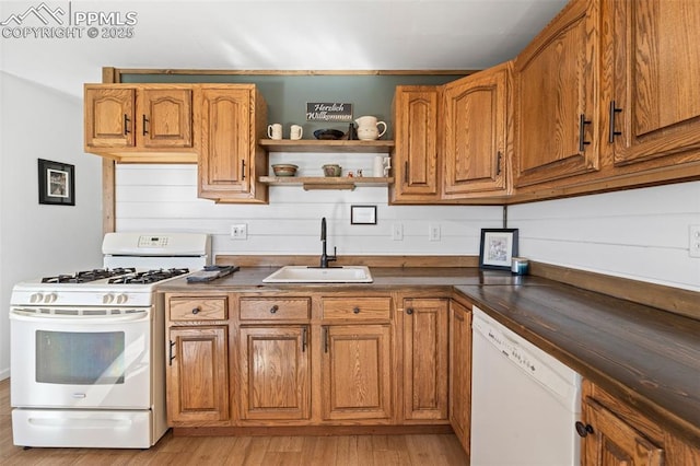 kitchen with white appliances, light hardwood / wood-style floors, and sink