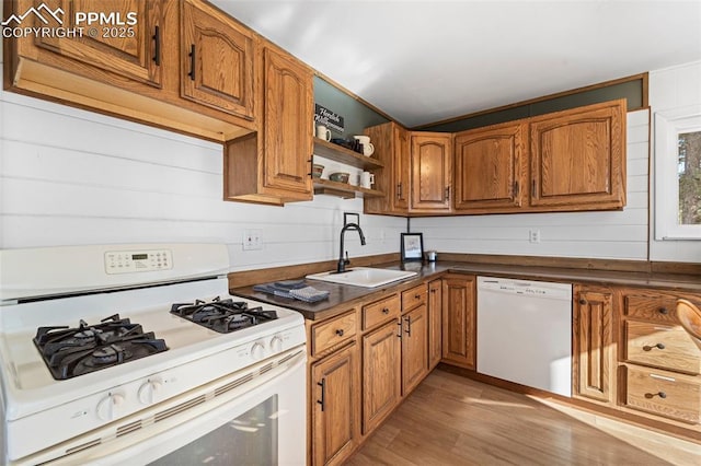 kitchen with sink, white appliances, and light hardwood / wood-style flooring