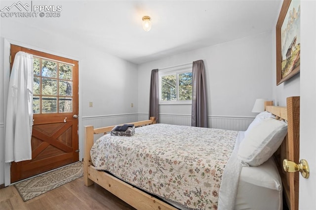 bedroom with multiple windows and hardwood / wood-style flooring