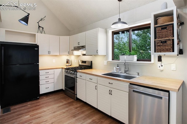 kitchen featuring appliances with stainless steel finishes, wood counters, decorative light fixtures, sink, and white cabinets