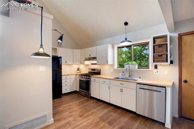 kitchen with stainless steel appliances, sink, hanging light fixtures, and white cabinets