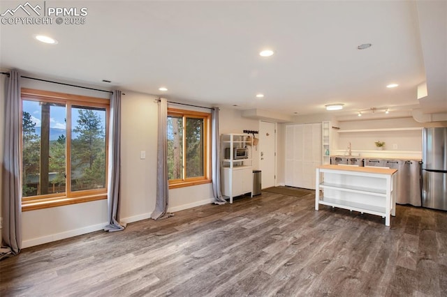 kitchen featuring hardwood / wood-style flooring and stainless steel fridge