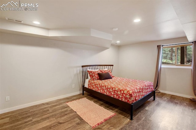 bedroom with dark hardwood / wood-style floors