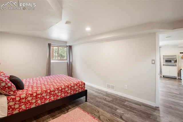 bedroom with dark hardwood / wood-style floors