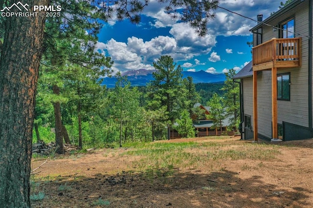 view of yard featuring a balcony and a mountain view