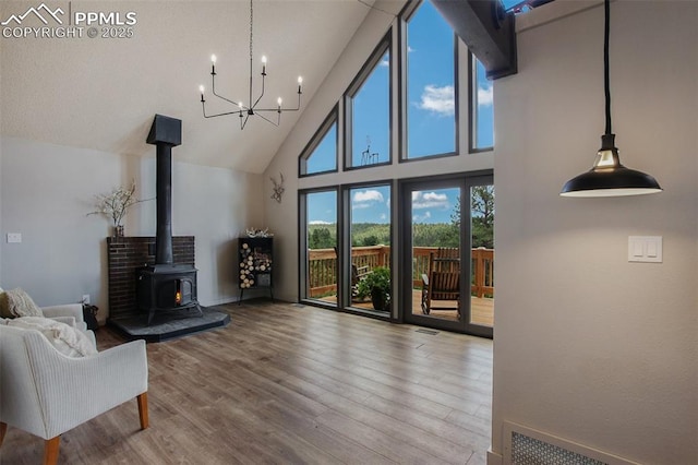 living room with wood-type flooring, a wood stove, and a high ceiling