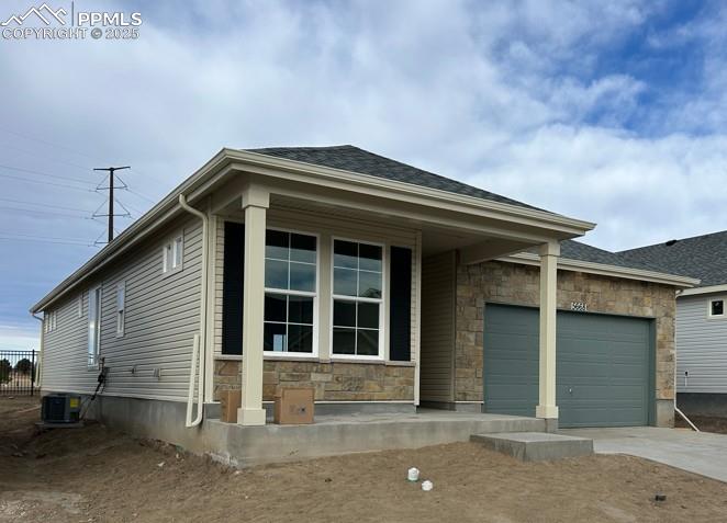 view of front of home with a garage and central air condition unit