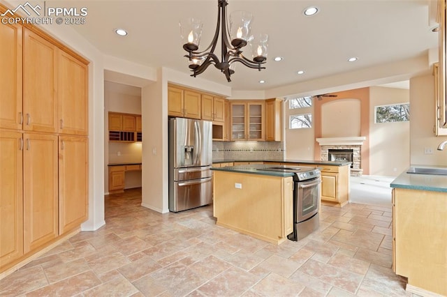 kitchen featuring appliances with stainless steel finishes, pendant lighting, tasteful backsplash, a center island, and light brown cabinets