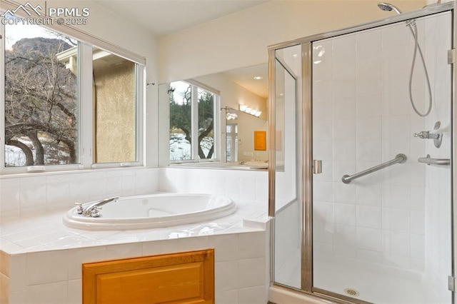 bathroom featuring shower with separate bathtub