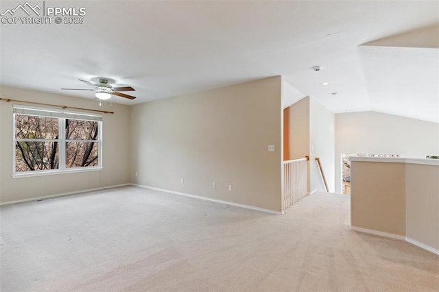 spare room featuring vaulted ceiling, light carpet, and ceiling fan