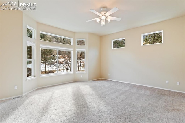 carpeted empty room with plenty of natural light and ceiling fan