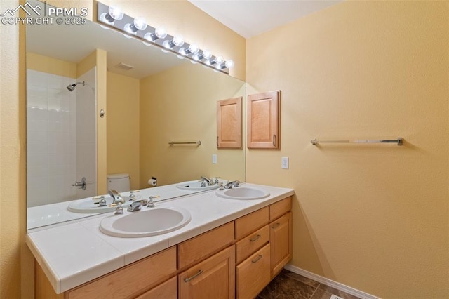 bathroom featuring vanity, walk in shower, and toilet