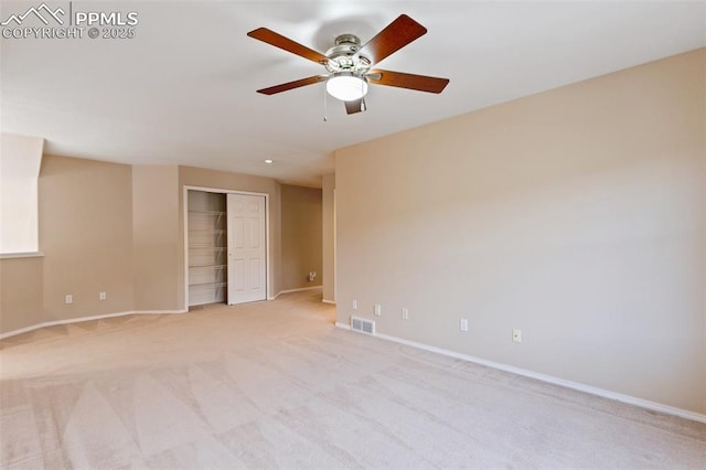 spare room with ceiling fan and light carpet