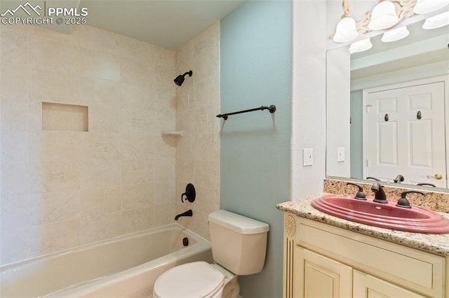 full bathroom featuring tiled shower / bath combo, vanity, and toilet