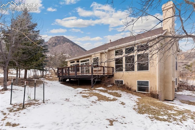 snow covered property featuring a deck with mountain view