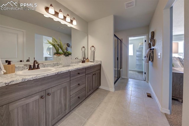 bathroom featuring walk in shower, vanity, and tile patterned flooring