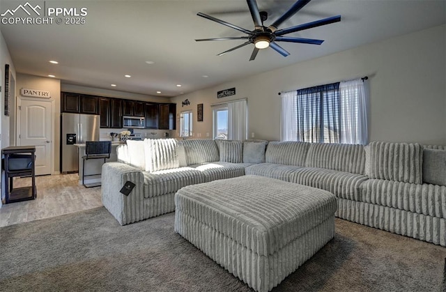living room featuring ceiling fan and light hardwood / wood-style floors