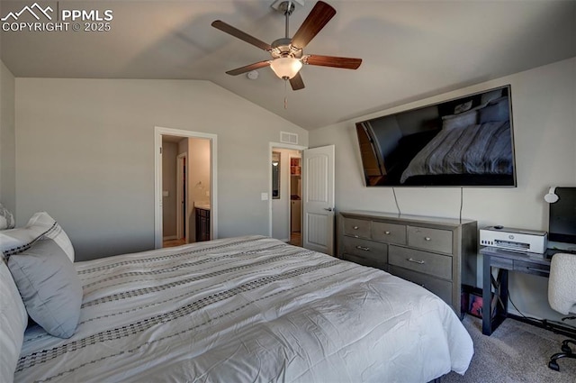 carpeted bedroom featuring vaulted ceiling, ensuite bathroom, and ceiling fan
