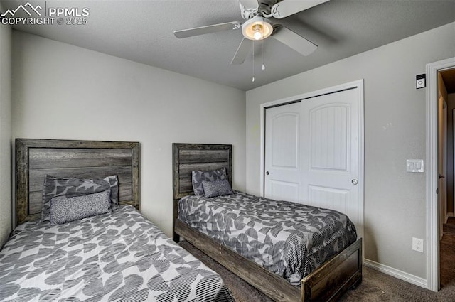 carpeted bedroom with a textured ceiling, ceiling fan, and a closet