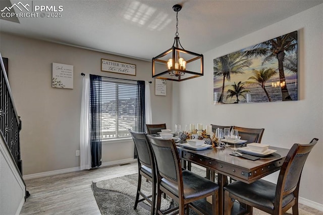 dining room featuring an inviting chandelier and light hardwood / wood-style flooring