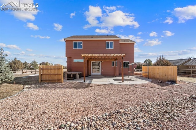 rear view of property featuring a pergola and a patio