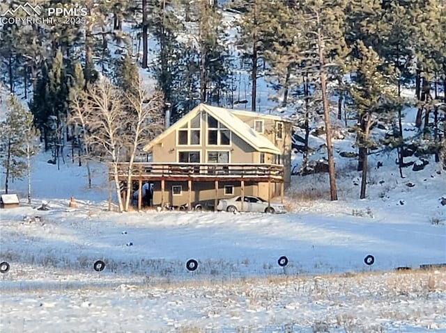 view of snow covered back of property