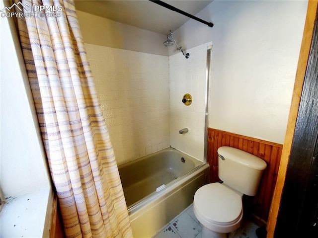 bathroom with toilet, shower / bath combo, and wood walls