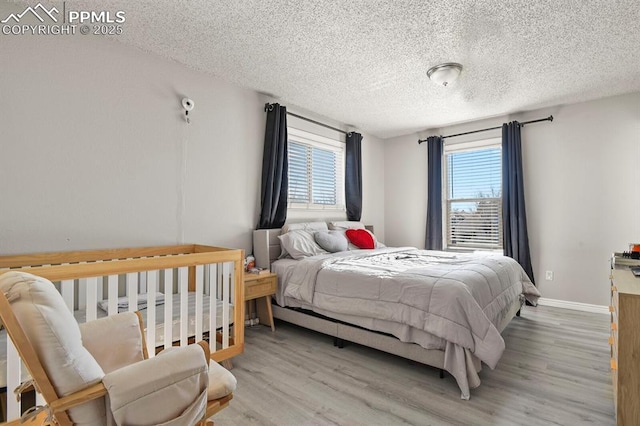 bedroom with light hardwood / wood-style flooring and a textured ceiling