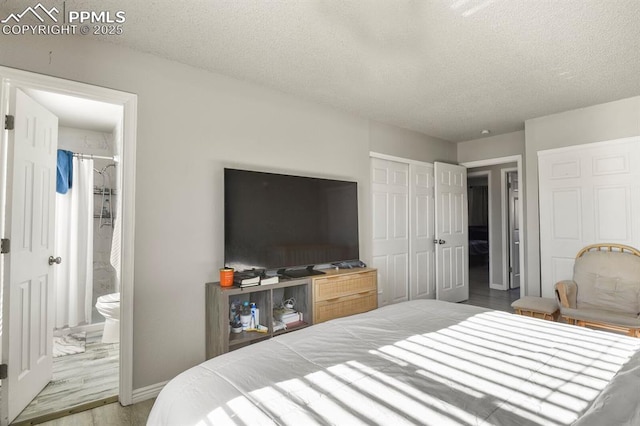 bedroom featuring wood-type flooring, connected bathroom, a closet, and a textured ceiling