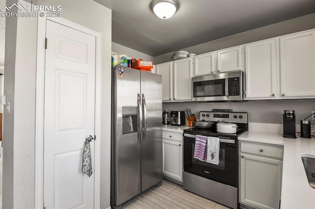 kitchen featuring stainless steel appliances and white cabinets