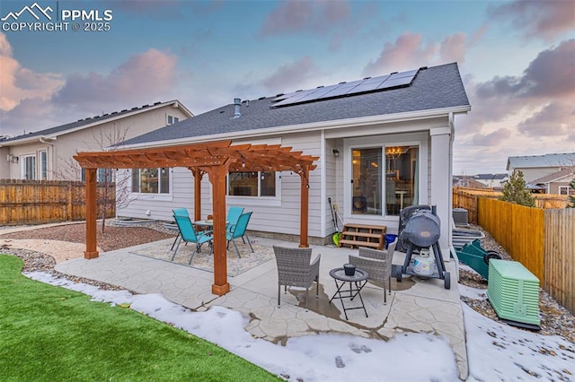 back house at dusk featuring solar panels, a pergola, central air condition unit, and a patio area